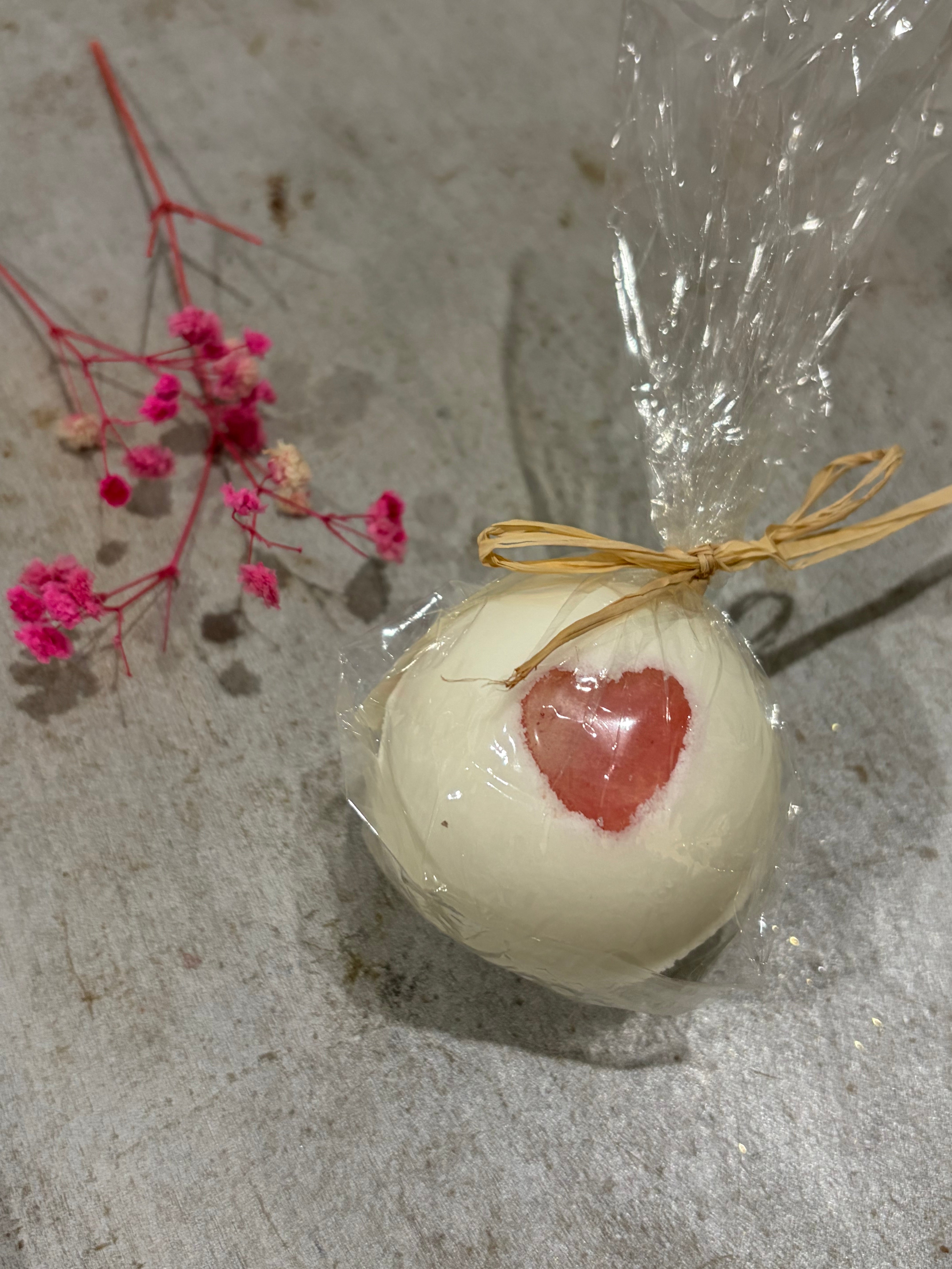 Badekugel mit Schaum mit einem Herz aus Rosenquarz als Glücksbringer